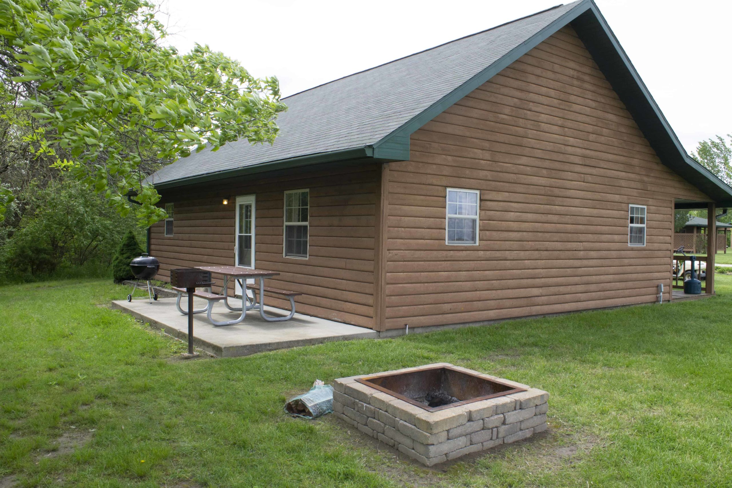 picnic table, grill, and firepit at vacation cabin rental site in shelbyville illinois